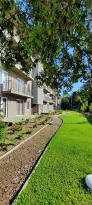 un grand immeuble d'appartements avec une pelouse verte en face de celui-ci dans l'établissement Pucón Soñado Te Espera, à Pucón