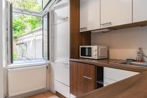 cocina con microondas y ventana en Modern 2BR Apt. Perfect for Long and Short Stays en Viena