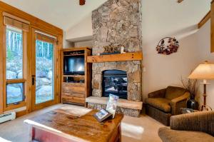uma sala de estar com uma lareira de pedra e um sofá em Keystone Private Homes by Keystone Resort em Keystone