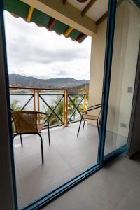a balcony with two chairs and a view of the mountains at Casa García Rent Home in Guatapé