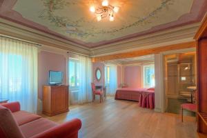 1 dormitorio con 1 cama, TV y sofá en Il Vicolo Relais, en Sirolo