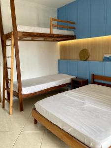 a room with three bunk beds in a room at Apartamento Frente para o mar in Ilha Comprida