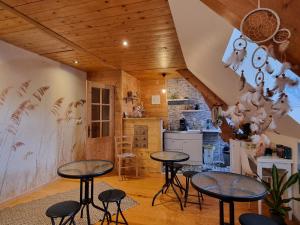 eine Küche mit Tischen und Stühlen in einem Zimmer in der Unterkunft Le Gentil Home Chambres d'Hôtes in Arras-en-Lavedan
