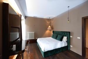 a bedroom with a bed with a green headboard at The Babuino - Luxury serviced apartment in Rome