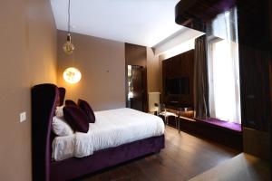um quarto com uma cama com almofadas em The Babuino - Luxury serviced apartment em Roma