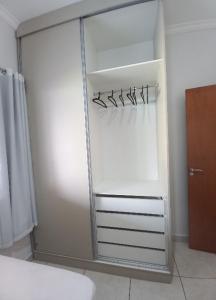 um frigorífico branco com um espelho num quarto em Casa Temporada BV Capitolio em Capitólio