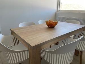 a wooden table with chairs and a bowl of oranges on it at Ivana apartman 2 in Lovište