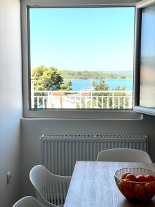 a dining room with a table and a large window at Ivana apartman 2 in Lovište