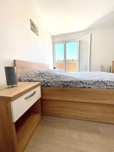 a bedroom with a bed with a desk and a window at Ivana apartman 2 in Lovište