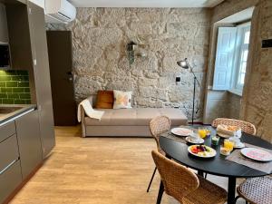 uma cozinha e uma sala de estar com mesa e cadeiras em Oca Ribeira do Porto AT em Porto