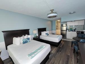 a hotel room with two beds and a kitchen at Tahitian Beach Resort in St Pete Beach