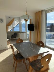 ein Esszimmer mit einem Tisch, Stühlen und einem Fenster in der Unterkunft Sunside Ferien Wellness Oase Hotel Apartment's Schwarzwald am Schluchsee in Schluchsee