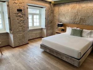 a bedroom with a large bed and two windows at Oca Ribeira do Porto AT in Porto