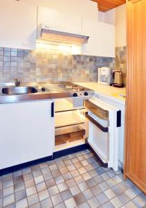 uma cozinha com armários brancos e um lavatório em Appartements Kirchmair em Seefeld in Tirol