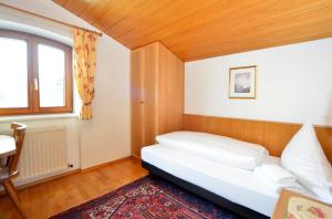 um pequeno quarto com uma cama e uma janela em Appartements Kirchmair em Seefeld in Tirol