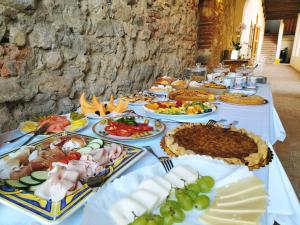 einen Tisch mit vielen verschiedenen Arten von Lebensmitteln in der Unterkunft Badia Giulia Prestigious Historical B&B, Camaiore Adults only - Pets free in Camaiore