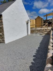 un edificio blanco con una puerta a un lado en Wildthorn Cottage, en Moyad