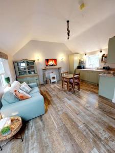 a living room with a blue couch and a kitchen at Wildthorn Cottage in Moyad