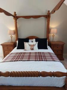 una camera da letto con un grande letto in legno con due comodini di Wildthorn Cottage a Moyad