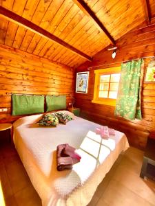 ein Schlafzimmer mit einem Bett in einer Holzhütte in der Unterkunft Canary Wild House 2 in Carrizal