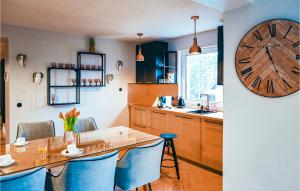 a kitchen with a table and a clock on the wall at Awesome Apartment In Stezyca With Sauna in Stężyca
