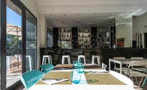 a dining room with tables and chairs and a bar at Hotel Checkin Valencia Ciscar in Picanya
