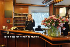 a woman talking on a cell phone in a salon at Ambassador Parkhotel in Munich