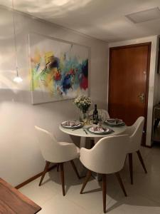 a table and chairs in a room with a painting at Tambaú Beach Paradise in João Pessoa