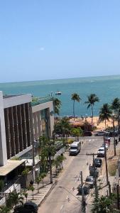 une rue avec des voitures garées à côté d'une plage dans l'établissement Tambaú Beach Paradise, à João Pessoa