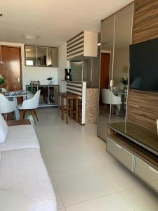 a room with a living room and a kitchen with a television at Tambaú Beach Paradise in João Pessoa