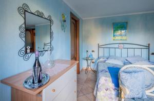 - une chambre avec un lit et une commode avec un miroir dans l'établissement L'Angolo delle Peonie, à Cannobio