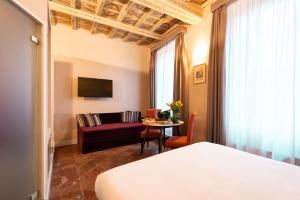 a hotel room with a bed and a couch and a table at Le Suite del Barone in Rome