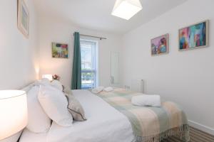 una camera bianca con un letto e una finestra di Puffins a St Ives