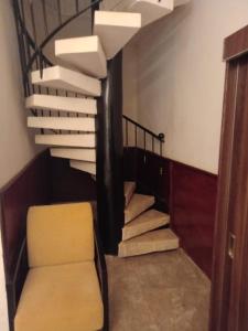 a stairway with a yellow chair and a spiral staircase at Iris Hotel in Dakar