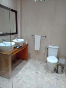 a bathroom with a sink and a toilet and a mirror at Iris Hotel in Dakar