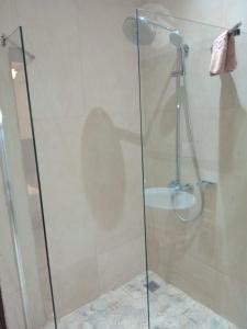 y baño con ducha y puerta de cristal. en Iris Hotel en Dakar