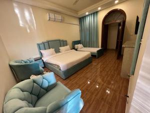 1 dormitorio con 2 camas y sofá en Heritage Inn, en Islamabad