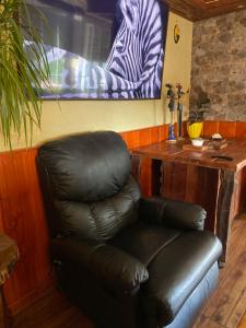 a leather chair in a room with a zebra picture at Centro de Temuco Depto único, rústico y a pasos de todo Incluye estacionamiento in Temuco