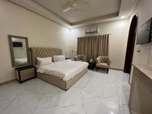 a bedroom with a bed and a mirror and a tv at Heritage Inn in Islamabad