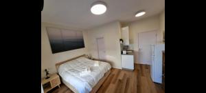 1 dormitorio con 1 cama blanca y cocina en Jaffa 17 - Lihi brand new studio en Jerusalén
