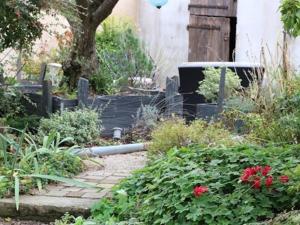 einen Garten mit einem Zaun und einigen Pflanzen und Blumen in der Unterkunft Le Corrigot in Pierry