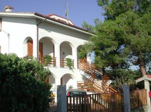 ein weißes Haus mit einer Treppe davor in der Unterkunft Mansarda seaview in Senigallia