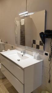 La salle de bains est pourvue d'un lavabo blanc et d'un miroir. dans l'établissement Albergo la Svolta, à Brescia