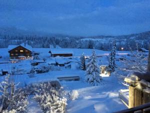a snow covered field with a house and trees at Leihwohnwagen Camping-Aach in Oberstaufen +6 photos