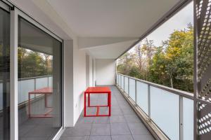 a red stool on the balcony of a house at Carré Huit in Marseille