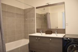 a bathroom with a sink and a tub and a mirror at Carré Huit in Marseille