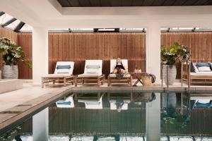 a woman sitting in a chair next to a swimming pool at Comwell Borupgaard in Snekkersten