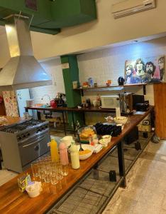 a kitchen with a table with food and wine glasses at Clover Hostel in Mendoza