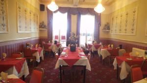 un comedor con mesas y sillas rojas en Abbey Court Hotel, en Torquay
