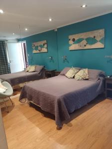 1 dormitorio con 2 camas y pared azul en Quinta Don Alfredo en Tandil